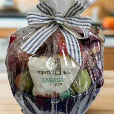 Gift basket wrapped in clear cellophane with a striped bow