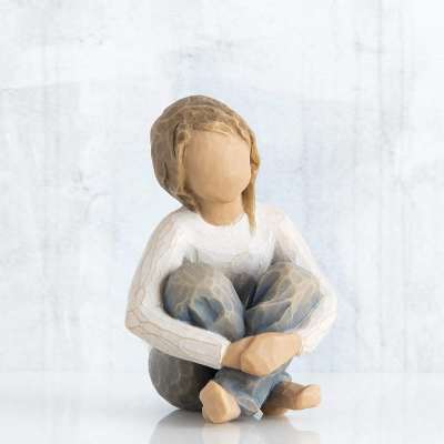 Wooden figurine of a seated child with knees hugged to chest