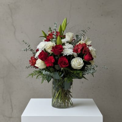 Red and white flower bouquet in a clear glass vase