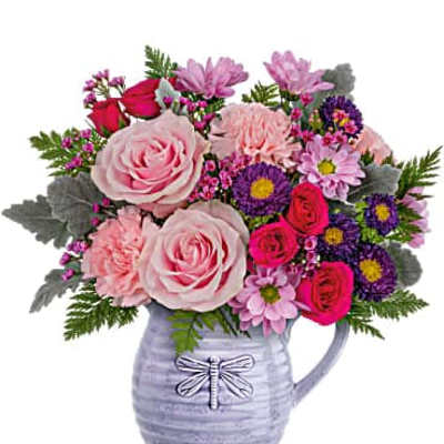 Bouquet of pink and purple flowers in a lavender pitcher vase