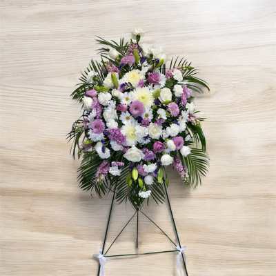 Standing floral spray with white, pink, and purple blooms on an easel
