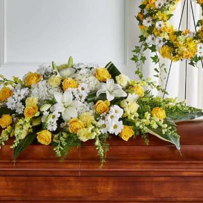 Yellow and white floral casket spray with lilies and roses