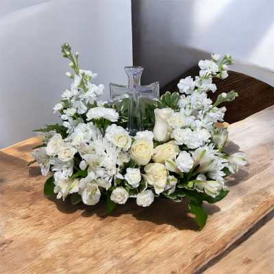 White floral arrangement with a clear glass cross centerpiece