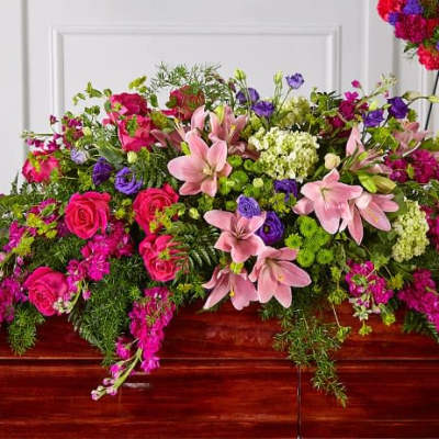 Large pink and purple floral casket spray with lilies and roses