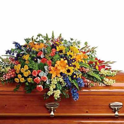 Large mixed flower spray on a wooden casket