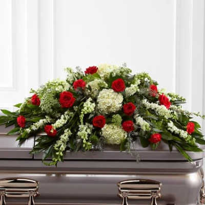 Red roses and white flowers arranged on a casket