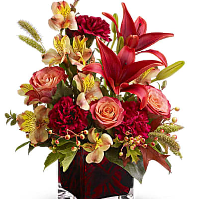 Red lilies and pink roses in a glass vase