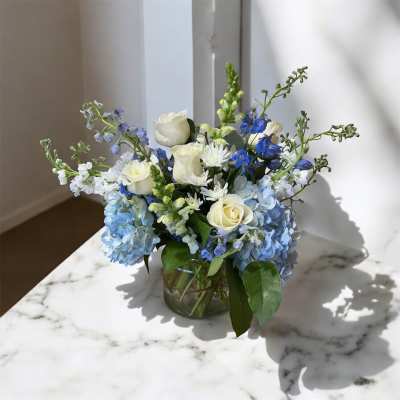 Blue and white flower arrangement in a glass vase