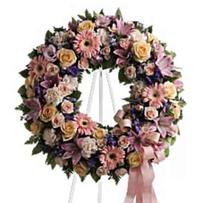 Floral wreath on a white easel with pink ribbon