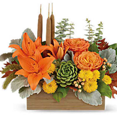 Orange lilies and roses in a wooden box with candles