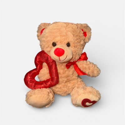 Teddy bear holding a red heart with a red ribbon
