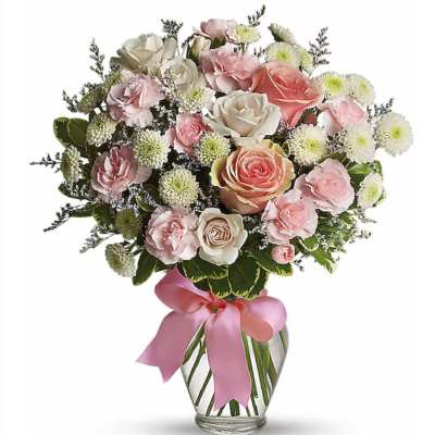 Bouquet of pink and white roses and carnations in a glass vase with a pink ribbon bow