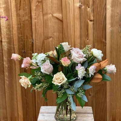 Bouquet of pale roses and white blooms in a glass vase