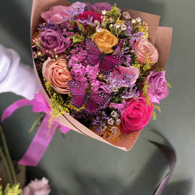 Bouquet of multicolored roses with two purple butterfly decorations