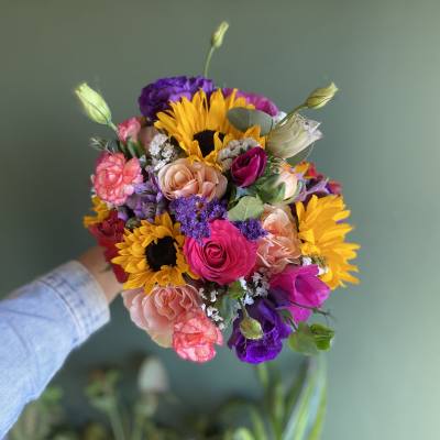 Handheld bouquet with sunflowers, roses, and purple blooms