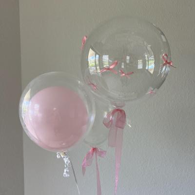 Pink and clear balloons tied with pink ribbons