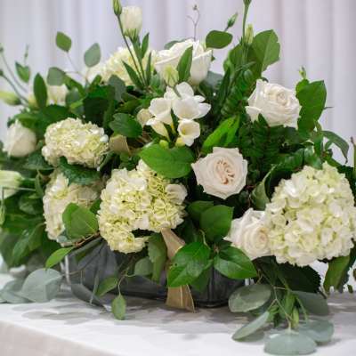 White roses and hydrangeas arranged in a low black container