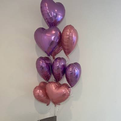 Pink rose bouquet with heart-shaped balloons above it