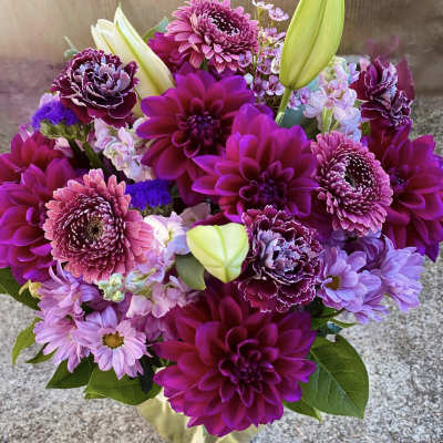 Bouquet of magenta and lavender flowers in a clear glass vase