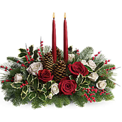 Holiday centerpiece with red candles, roses, pinecones, and evergreen branches