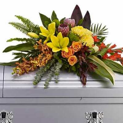 Colorful floral spray arranged on top of a casket