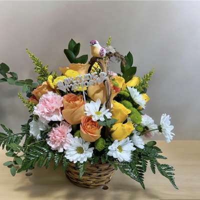 Basket arrangement of yellow and peach roses with white daisies and pink carnations