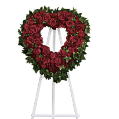 Heart-shaped red rose wreath on a white easel