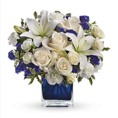 White lilies and cream roses in a blue glass vase