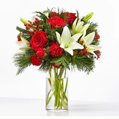 Red roses and white lilies arranged in a clear glass vase