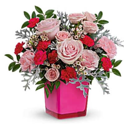 Pink and red rose and carnation arrangement in a bright pink cube vase