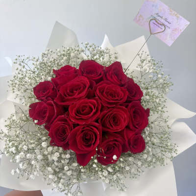 Bouquet of red roses with white baby's breath in white wrap