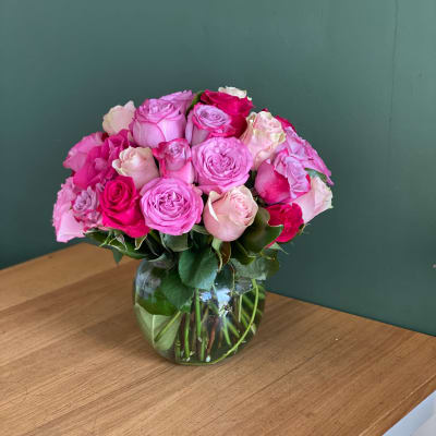 Pink and white roses arranged in a clear glass vase