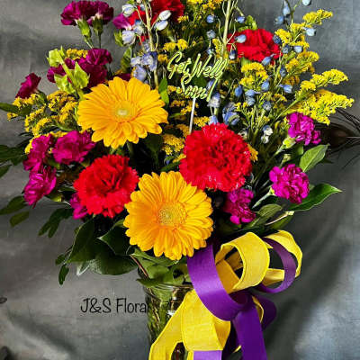 Colorful mixed bouquet in a glass vase with a Get Well Soon pick