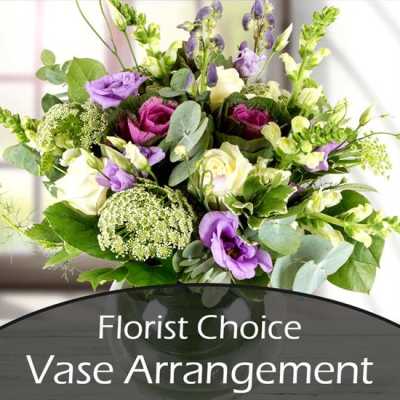 Mixed purple, white, and green flowers in a vase arrangement
