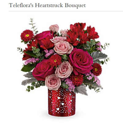 Bouquet of red and pink roses in a red heart-patterned vase