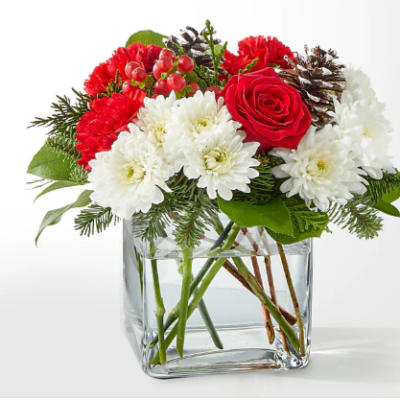 Red and white flower arrangement in a clear glass vase