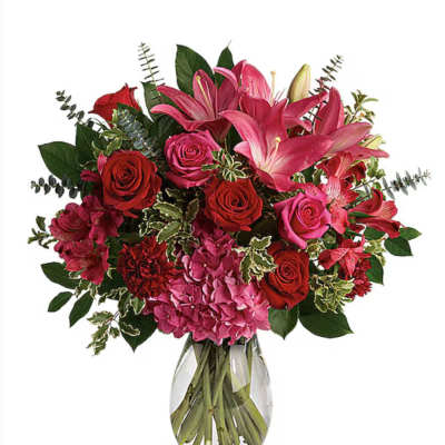 Bouquet of pink lilies, red and pink roses in a glass vase