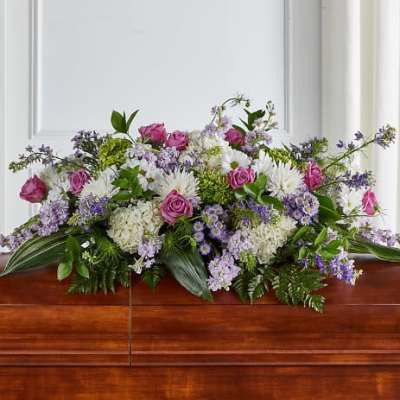 Low floral arrangement with pink roses, white blooms, and purple flowers