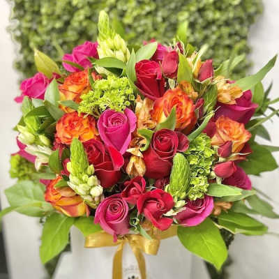 Bright pink and orange mixed bouquet in a white hatbox with gold ribbon