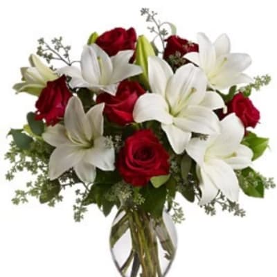 Red roses and white lilies in a clear glass vase