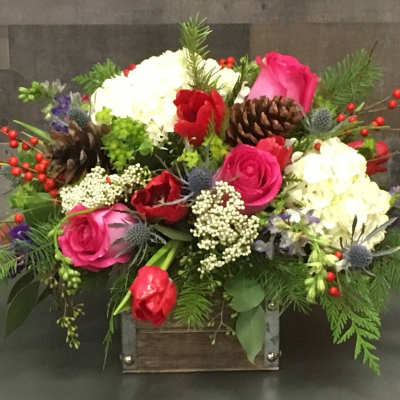 Mixed bouquet with pink and red roses, white blooms, and pinecones in a wooden box