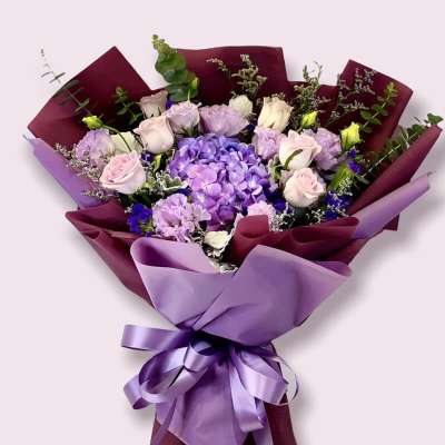 Bouquet of purple and pink flowers wrapped in burgundy and lavender paper