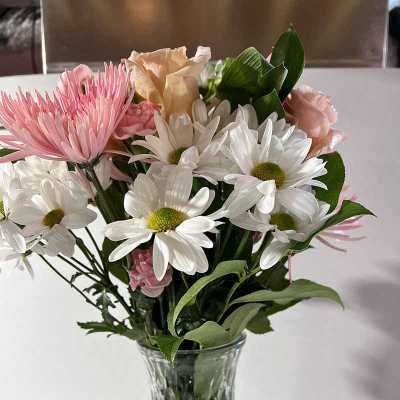 Pink and white flowers arranged in a clear glass vase