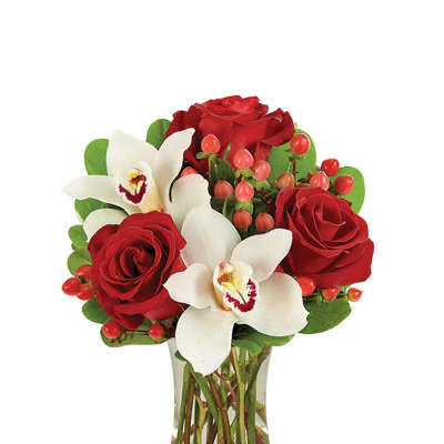 Red roses and white orchids in a clear glass vase