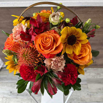 Basket of orange, yellow, and red mixed flowers