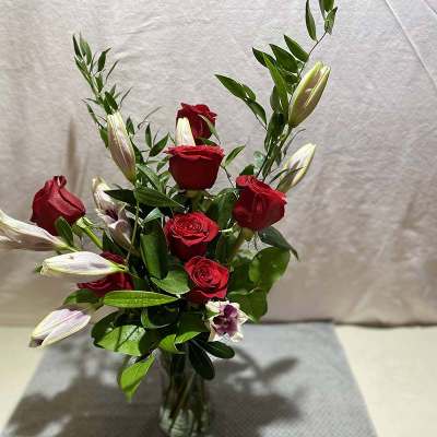 Red roses and white lilies in a clear glass vase