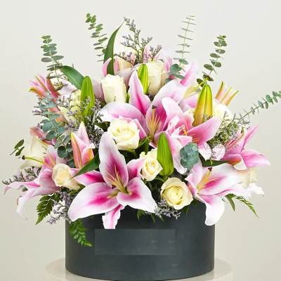 Pink lilies and white roses arranged in a black box