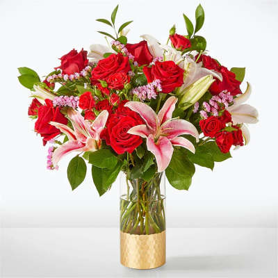 Bouquet of red roses and pink lilies in a glass vase
