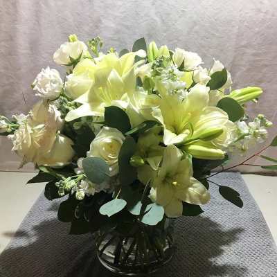 White lily and rose bouquet in a clear glass vase