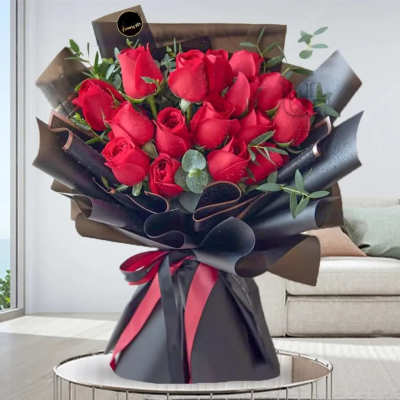 Bouquet of red roses wrapped in black paper with a ribbon